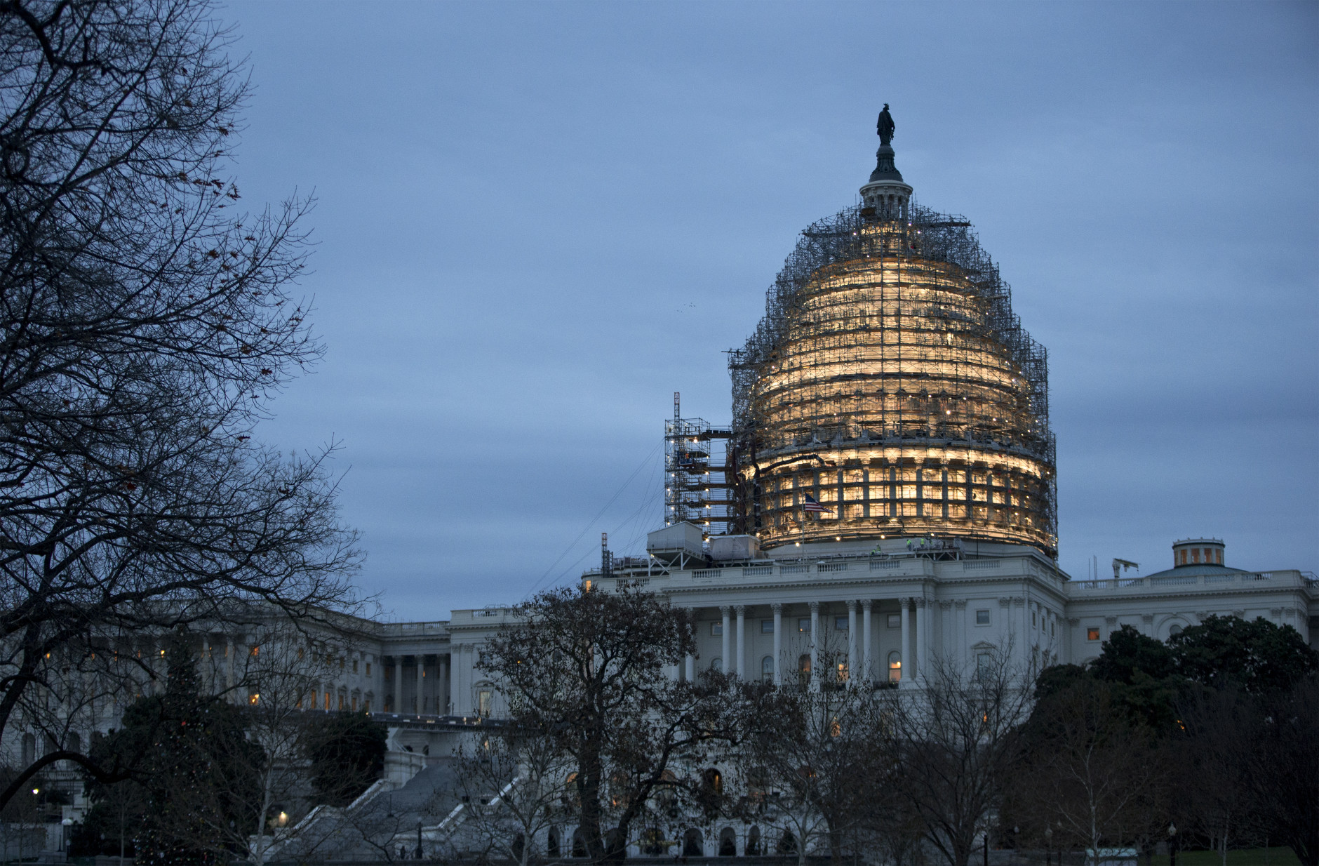 The Capitol Dome is illuminated amid scaffolding for repairs in Washington, Friday morning, Dec. 18, 2015.  The House and Senate race to wrap up votes on a massive spending and tax package, which President Barack Obama promises to sign.  (AP Photo/J. Scott Applewhite)