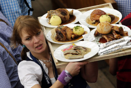 A waitress serves traditional food at the second weekend in the 'Hofbraeuhaus beer tent' at the famous beer festival Oktoberfest in Munich, southern Germany, Sunday, Sept. 28, 2014. The world's largest beer festival will be held from Sept. 22 to Oct. 5, 2014. (AP Photo/Matthias Schrader)