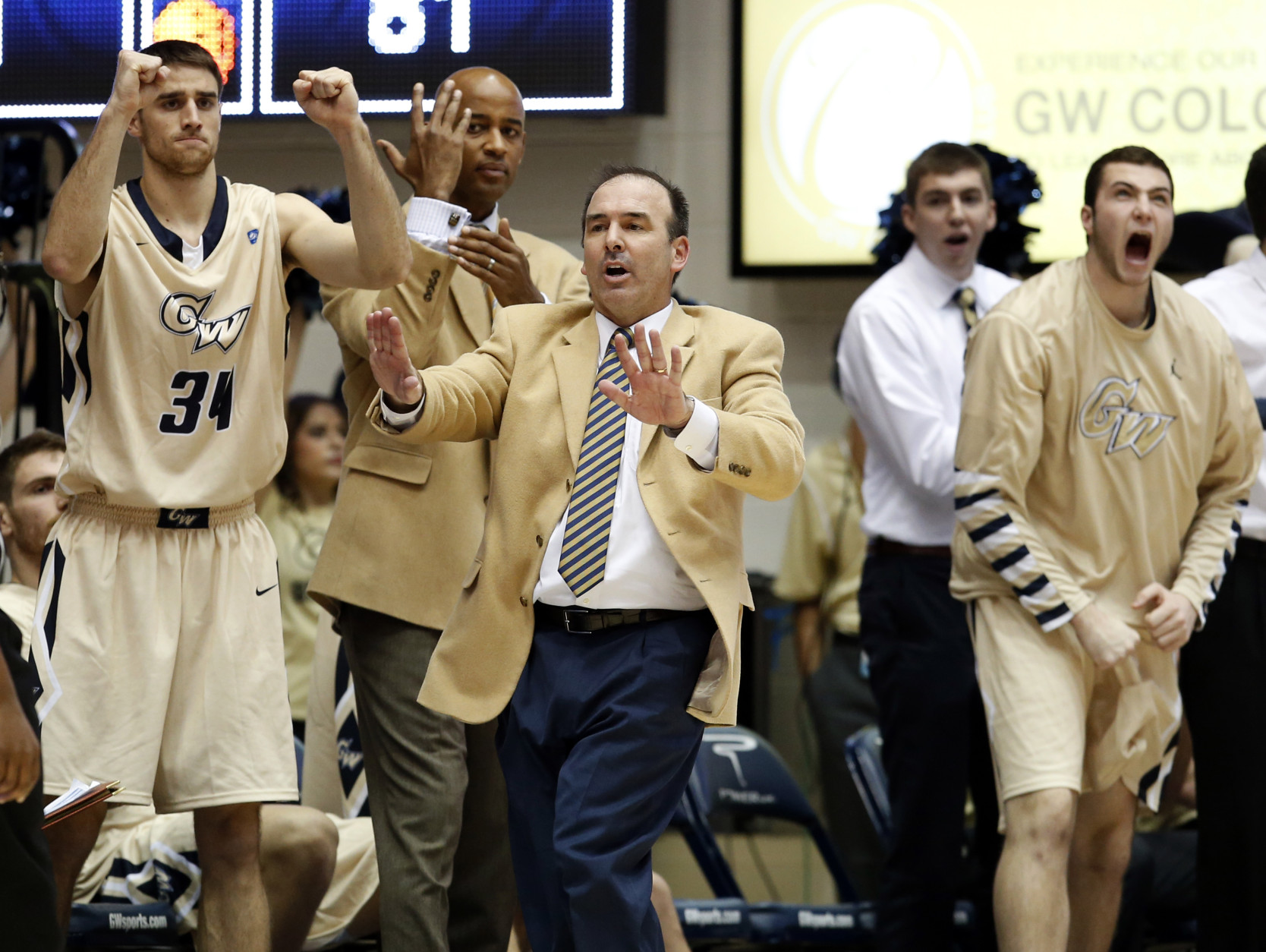 George Washington head coach Mike Lonergan, center, reacts with his team during the second half of an NCAA college basketball game against Rutgers, Wednesday, Dec. 4, 2013, in Washington. George Washington won 93-87. (AP Photo/Alex Brandon)