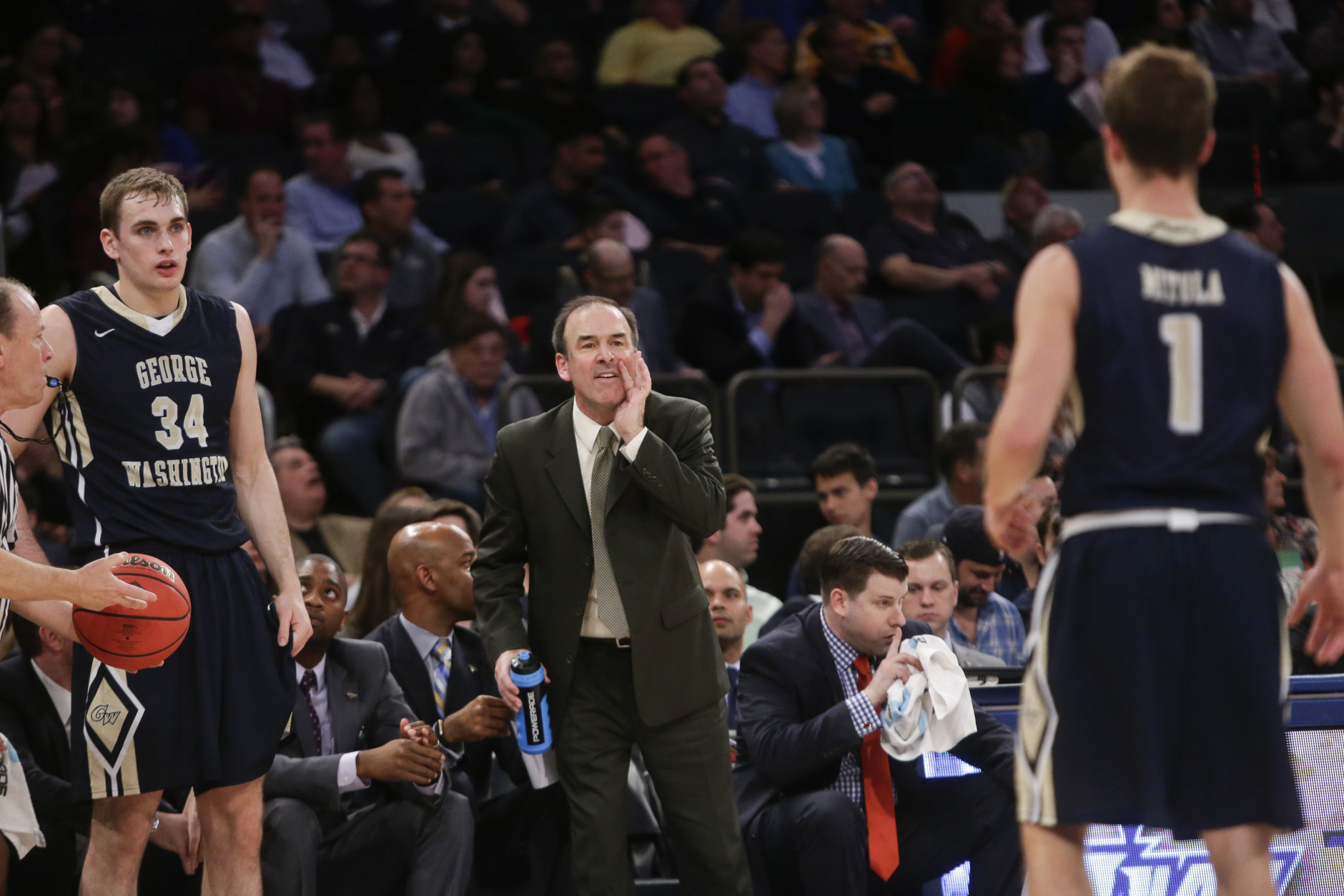 George Washington  head coach Mike Lonergan calls out to Alex Mitola (1) as Tyler Cavanaugh (34) waits to inbound the ball during the first half of an NCAA college basketball game against Valparaiso in the finals of the NIT Thursday, March 31, 2016, in New York. (AP Photo/Frank Franklin II)