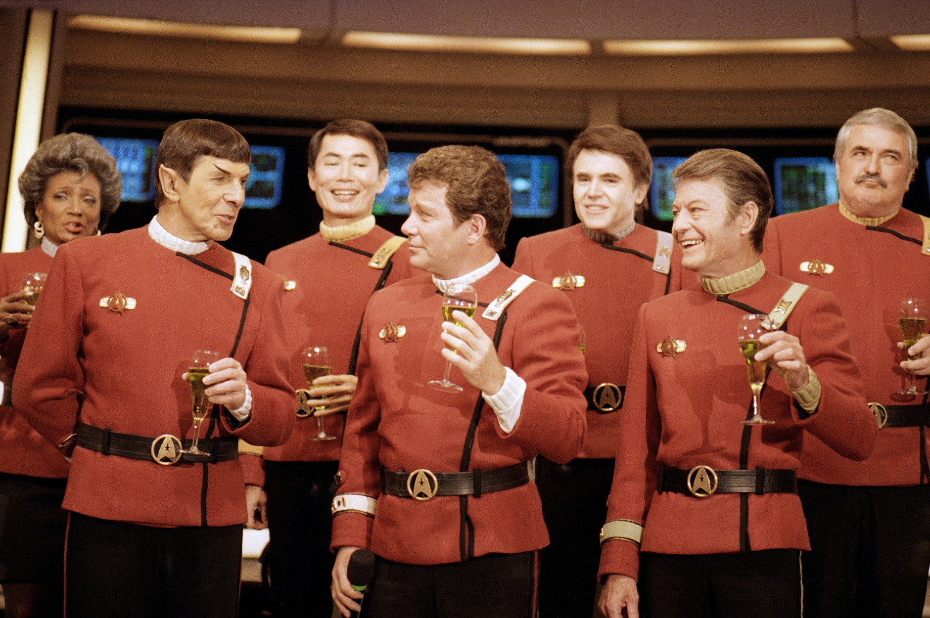 Members of the "Star Trek" crew, from right in front: DeForest Kelley, William Shanter and Leonard Nimoy, and back row from right: James Doohan, Walter Koenig, George Takei and Nichelle Nichols, toast the newest "Trek" film--in which Shanter makes his directorial debut--"Star Trek V: The Final Frontier," during a news conference Dec. 28, 1988 at Paramount Studios to announce the latest voyage. (AP Photo/Bob Galbraith)