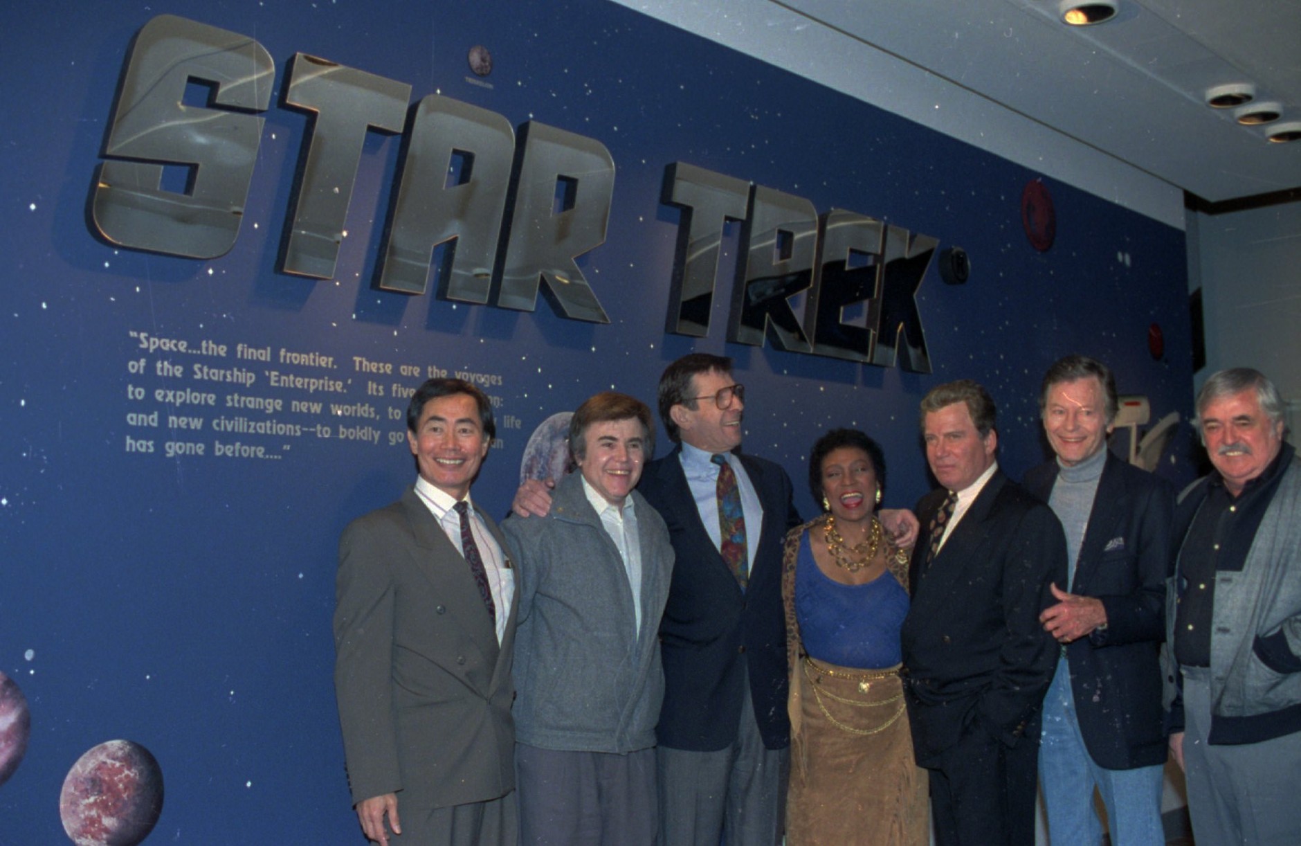Cast members of the origninal Star Trek series pose at the entrance of the Star Trek exhibit at the Smithsonian's National Air and Space Museum in Washington Feb. 26,1992. From left, are: George Takei, Walter Koenig, Leonard Nimoy, Nichelle Nichols, William Shatner, DeForest Kelley, and James Doohan. The actors were on hand for the exhibit opening. (AP Photo/Ron Edmonds)