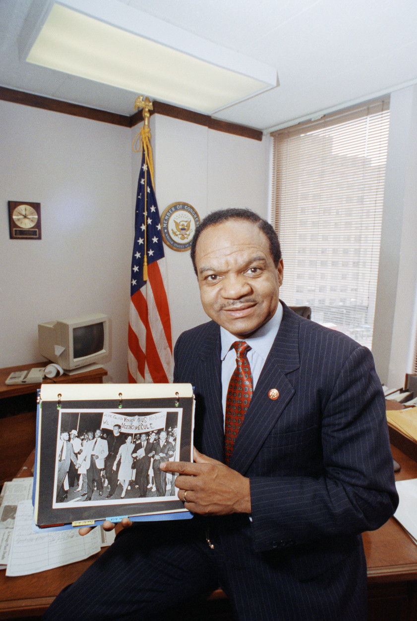 Former District of Columbia Rep. Walter Fauntroy points to a photograph he holds in his Washington office showing the Rev. Martin Luther King Jr in a 1963 civil rights march  March 29, 1993. Fauntroy, who headed the House committee that investigated Kings assassination, has joined historians calling for an independent re-investigation of the civil rights leaders death 25 years ago in Memphis. (AP Photo/Charles Tasnadi)