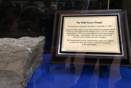 A plaque next to a piece of limestone from the Pentagon damaged in the Sept. 11 terror attacks recalls Dulles International Airport's role in the attacks. The plane that flew into the Pentagon took off from Dulles. (WTOP/Kristi King)