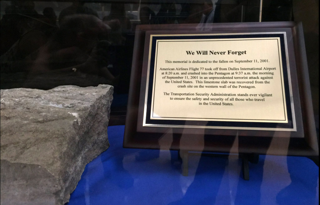 A plaque next to a piece of limestone from the Pentagon damaged in the Sept. 11 terror attacks recalls Dulles International Airport's role in the attacks. The plane that flew into the Pentagon took off from Dulles. (WTOP/Kristi King)