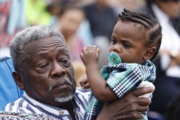 A man holds a child in the crowd during the opening dedication ceremony for the National Museum of African American History and Culture on Saturday, Sept. 24, 2016. (WTOP/Kate Ryan)