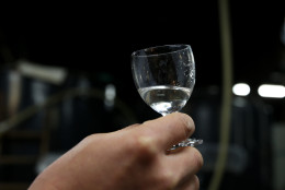 HIMEJI, JAPAN - JANUARY 22:  Japanese sake brewery worker holds up a glass of freshly made sake at Tanaka Sake Brewery on January 22, 2014 in Himeji, Japan. Japanese Prime Minister Shinzo Abe targets 60 billion yen by 2020, a fivefold increase in rice-based product exports including sake.  (Photo by Buddhika Weerasinghe/Getty Images)