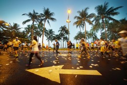 HONOLULU, HAWAII - DECEMBER 13:  2015 Honolulu Marathon runners head down Kalakaua Avenue adorned with tropical Coconut Trees. December 13, 2015.   Honolulu, Hawaii. December 13, 2015.  (Photo by Cory Lum/Getty Images for HONOLULU MARATHON)