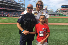 Lanier, Stancil and K9 Officer Steve Gianni stand on the field at Nationals Park. Gianni was one of the officers who helped save Stancil's life. (WTOP/Mike Murillo)
