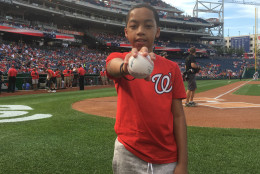 Jaydan Stancil, who was hit by a stray bullet when he was 9 years old in 2014, holds a ball signed by Ryan Zimmerman. He threw the first pitch at Monday's game. (WTOP/Mike Murillo)