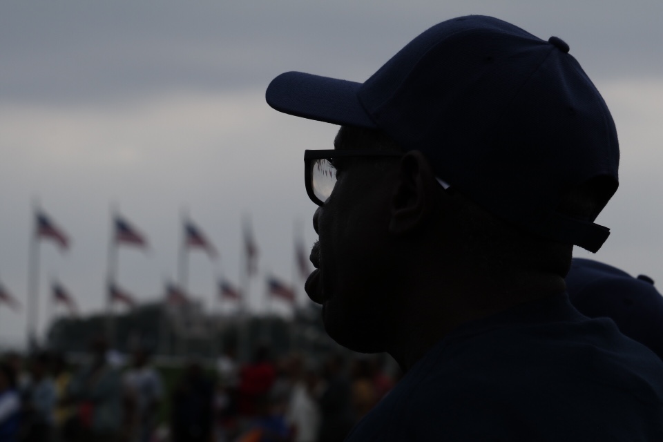 A man watches the events from the official opening of the National Museum of African American History and Culture, Sept. 24, 2016. (WTOP/Kate Ryan)