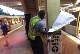 A Metro staff worker removes temporary signage that directed commuters to the wrong trains at the West Falls Church Metrorail station on Thursday, Sept. 15, 2016, when the ninth and longest phase of Metro’s system wide maintenance overhaul began. (WTOP/Neal Augenstein)