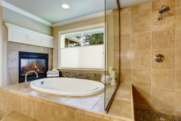 Classic American bathroom with whithe bath tub and shower. Also fireplace