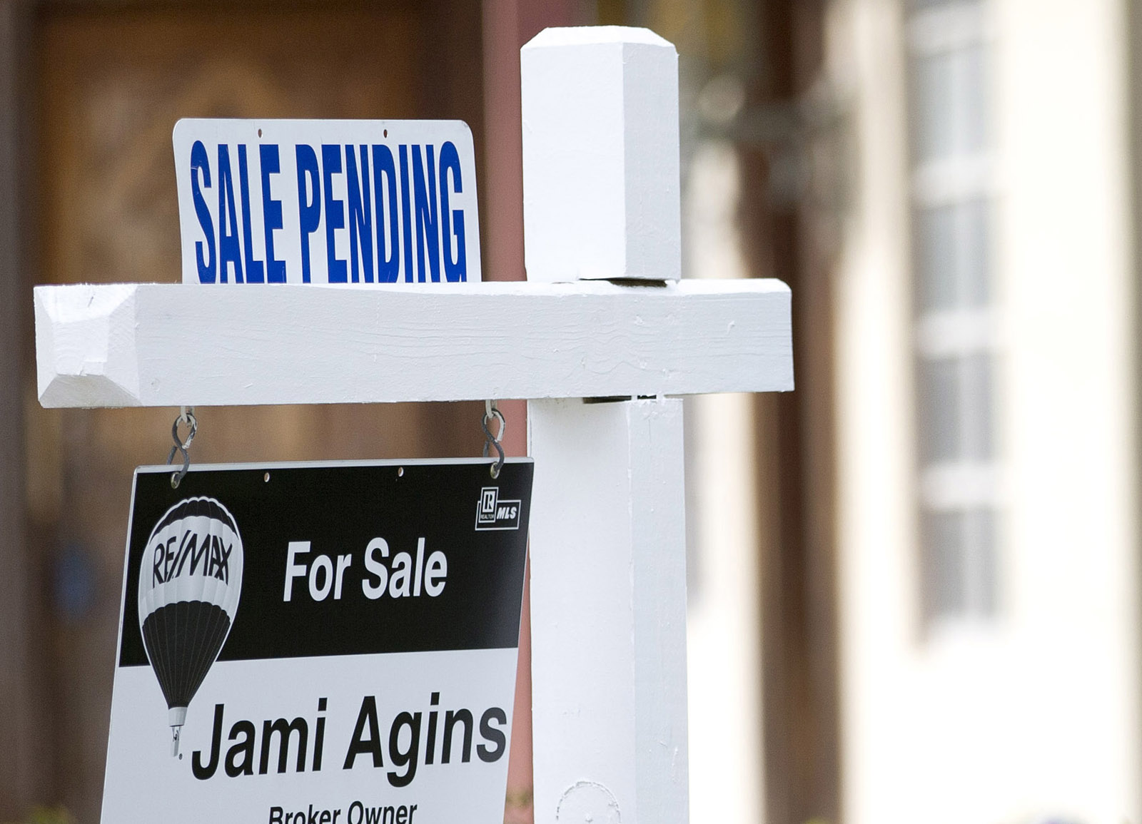 FILE - In this Thursday, Jan. 8, 2015, file photo, a "Sale Pending" sign sits atop a realty sign outside a home for sale in Surfside, Fla. The National Association of Realtors releases its March 2016 report on pending home sales on Wednesday, April 27, 2016. (AP Photo/Wilfredo Lee, File)