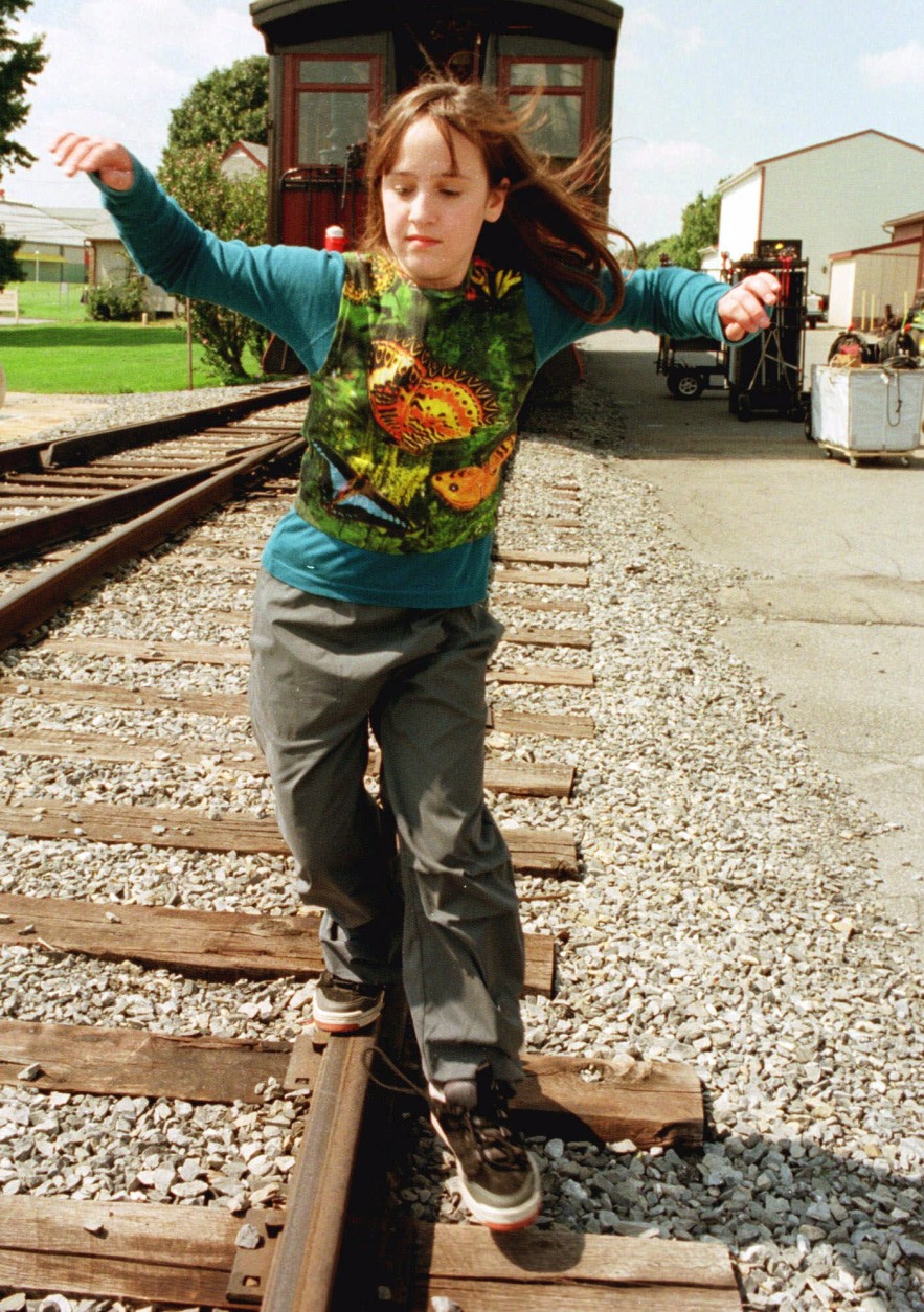 Actress Mara Wilson balances herself as she walks the rails as she relaxes during a lunck break in the filming of the "Thomas and the Magic Railroad" movie in Strasburg, Pa., Monday, Sept. 13, 1999. Mara plays 10-year-old Lily in the magical journey movie. (AP Photo/Paul Vathis)