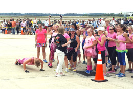 Mommy Boot Camp flexes before taking the FedEx plane down during the Plane Pull at Dulles International Airport on Saturday, Sept. 17, 2016. (WTOP/Ralph Fox)