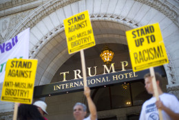 Demonstrators stand outside the Trump International Hotel during it's 'soft-opening' in downtown Washington, Monday, Sept. 12, 2016 in Washington. The luxury hotel Donald Trump has built in an iconic downtown Washington building is set to open. The Trump International Hotel will begin serving guests Monday. There won't be any fanfare around the opening, which is known as a "soft opening." Grand-opening ceremonies are being planned for October. The Trump Organization won a 60-year lease from the federal government to transform the Old Post Office building on Pennsylvania Avenue into a hotel. (AP Photo/Pablo Martinez Monsivais)