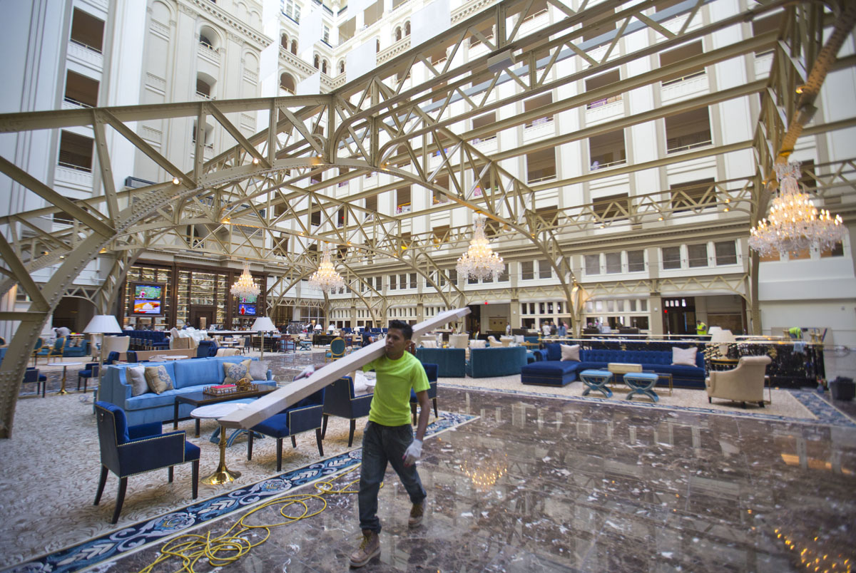 Workers continue work at the Trump International Hotel during the 'soft-opening' in downtown Washington, Monday, Sept. 12, 2016 in Washington. The luxury hotel Donald Trump has built in an iconic downtown Washington building is set to open. The Trump International Hotel will begin serving guests Monday. There won't be any fanfare around the opening, which is known as a "soft opening." Grand-opening ceremonies are being planned for October. The Trump Organization won a 60-year lease from the federal government to transform the Old Post Office building on Pennsylvania Avenue into a hotel. (AP Photo/Pablo Martinez Monsivais)