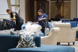 Workers vacuum furniture in the lobby at the Trump International Hotel in downtown Washington, Monday, Sept. 12, 2016 in Washington. The luxury hotel Donald Trump has built in an iconic downtown Washington building is set to open. The Trump International Hotel will begin serving guests Monday. There won't be any fanfare around the opening, which is known as a "soft opening." Grand-opening ceremonies are being planned for October. The Trump Organization won a 60-year lease from the federal government to transform the Old Post Office building on Pennsylvania Avenue into a hotel. (AP Photo/Pablo Martinez Monsivais)