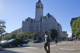 Pedestrians cross Pennsylvania Ave., across the street from the Trump International Hotel in downtown Washington, Monday, Sept. 12, 2016. The luxury hotel Donald Trump has built in an iconic downtown Washington building is set to open. The Trump International Hotel will begin serving guests Monday. There won't be any fanfare around the opening, which is known as a "soft opening." Grand-opening ceremonies are being planned for October. The Trump Organization won a 60-year lease from the federal government to transform the Old Post Office building on Pennsylvania Avenue into a hotel. (AP Photo/Pablo Martinez Monsivais)