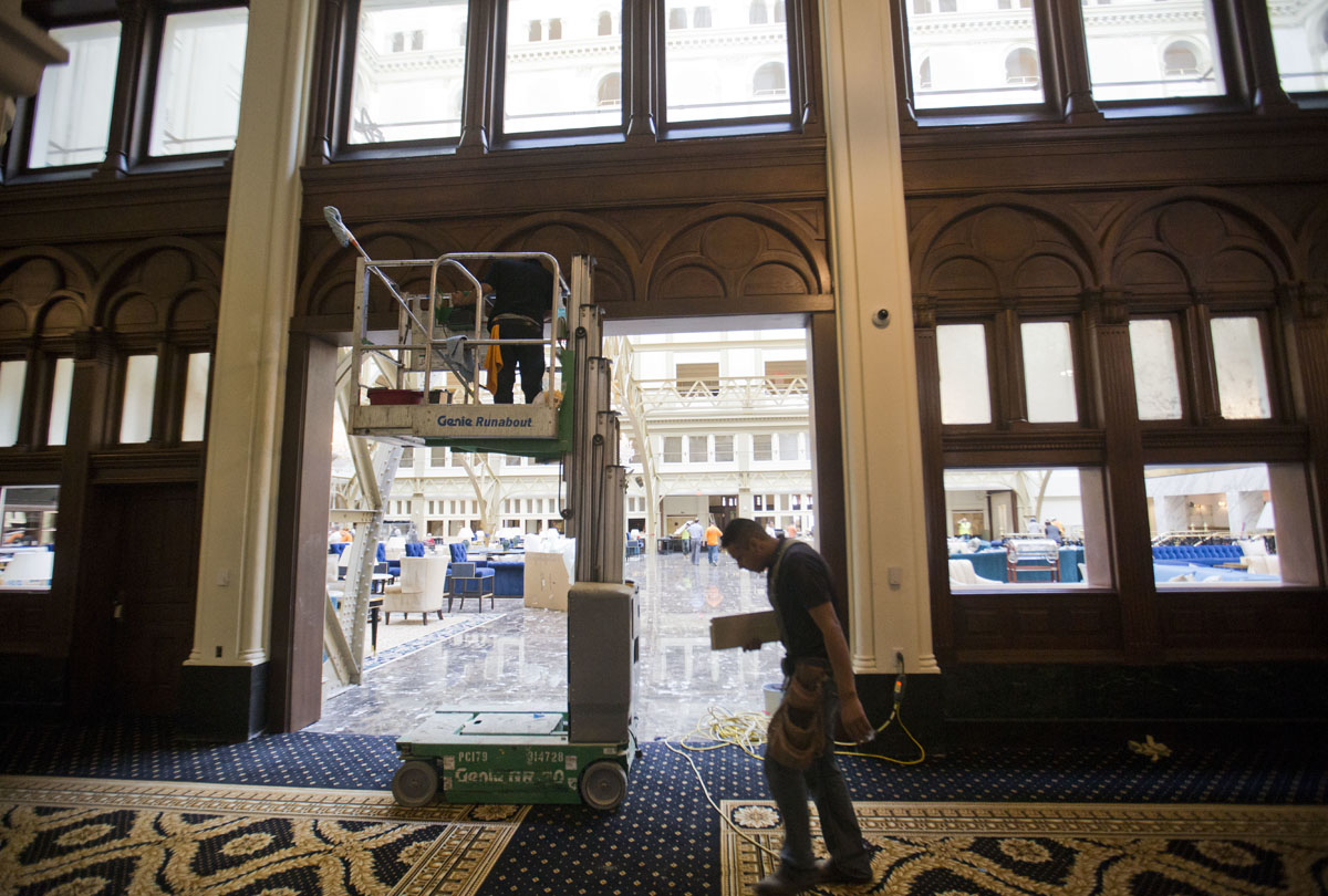 Work continues inside as the final details are made to the lobby area of the Trump International Hotel in downtown Washington, Monday, Sept. 12, 2016. The luxury hotel Donald Trump has built in an iconic downtown Washington building is set to open. The Trump International Hotel will begin serving guests Monday. There won't be any fanfare around the opening, which is known as a "soft opening." Grand-opening ceremonies are being planned for October. The Trump Organization won a 60-year lease from the federal government to transform the Old Post Office building on Pennsylvania Avenue into a hotel. (AP Photo/Pablo Martinez Monsivais)