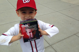 Tucker Prohaska shows off his prize from the Center Field plaza bag grab. The 3-year-old is wearing part of his Jayson Werth Halloween costume his dad says he won't take off. He didn't bring the shaggy beard. (WTOP/Megan Cloherty)