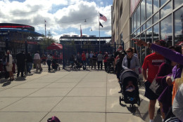 Fans lines up outside Nats park, many playing hookie from work to drop off a good luck charm and a chance to win postseason tickets. (WTOP/Megan Cloherty)