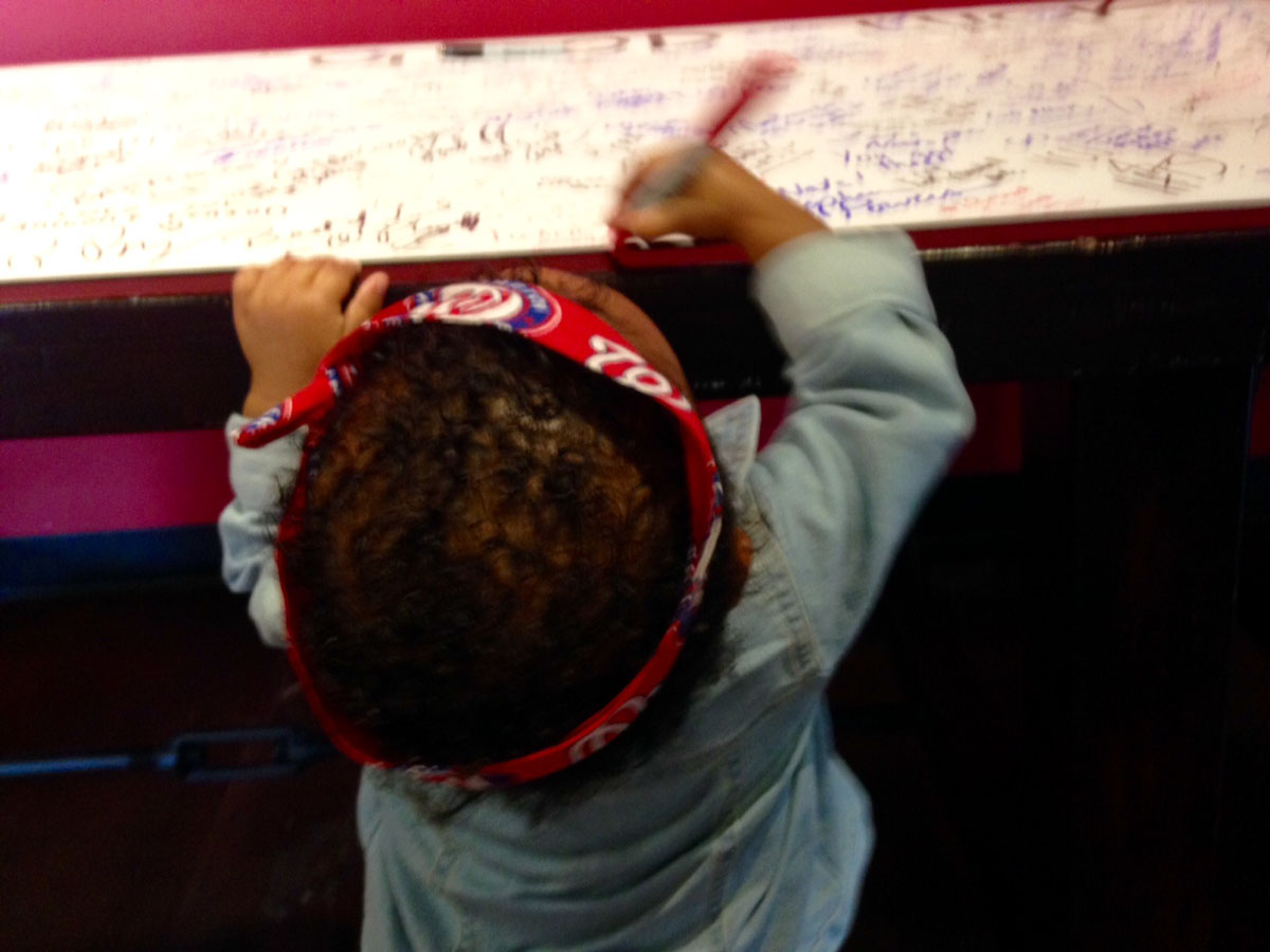 Anora, 17 months, leaves a good luck scribble. (WTOP/Megan Cloherty)
