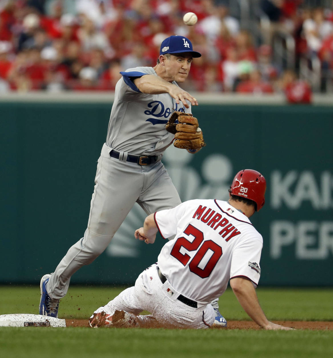 Los Angeles Dodgers second baseman Chase Utley throws to first base after getting the out on Washington Nationals' Daniel Murphy, but can't get the double play on Anthony Rendon during the second inning of Game 1 of a baseball National League Division Series, at Nationals Park, Friday, Oct. 7, 2016, in Washington. (AP Photo/Alex Brandon)
