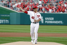 Injured Washington Nationals catcher Wilson Ramos throws out a ceremonial first pitch before Game 1 of baseball's National League Division Series against the Los Angeles Dodgers, at Nationals Park, Friday, Oct. 7, 2016, in Washington. (AP Photo/Alex Brandon)