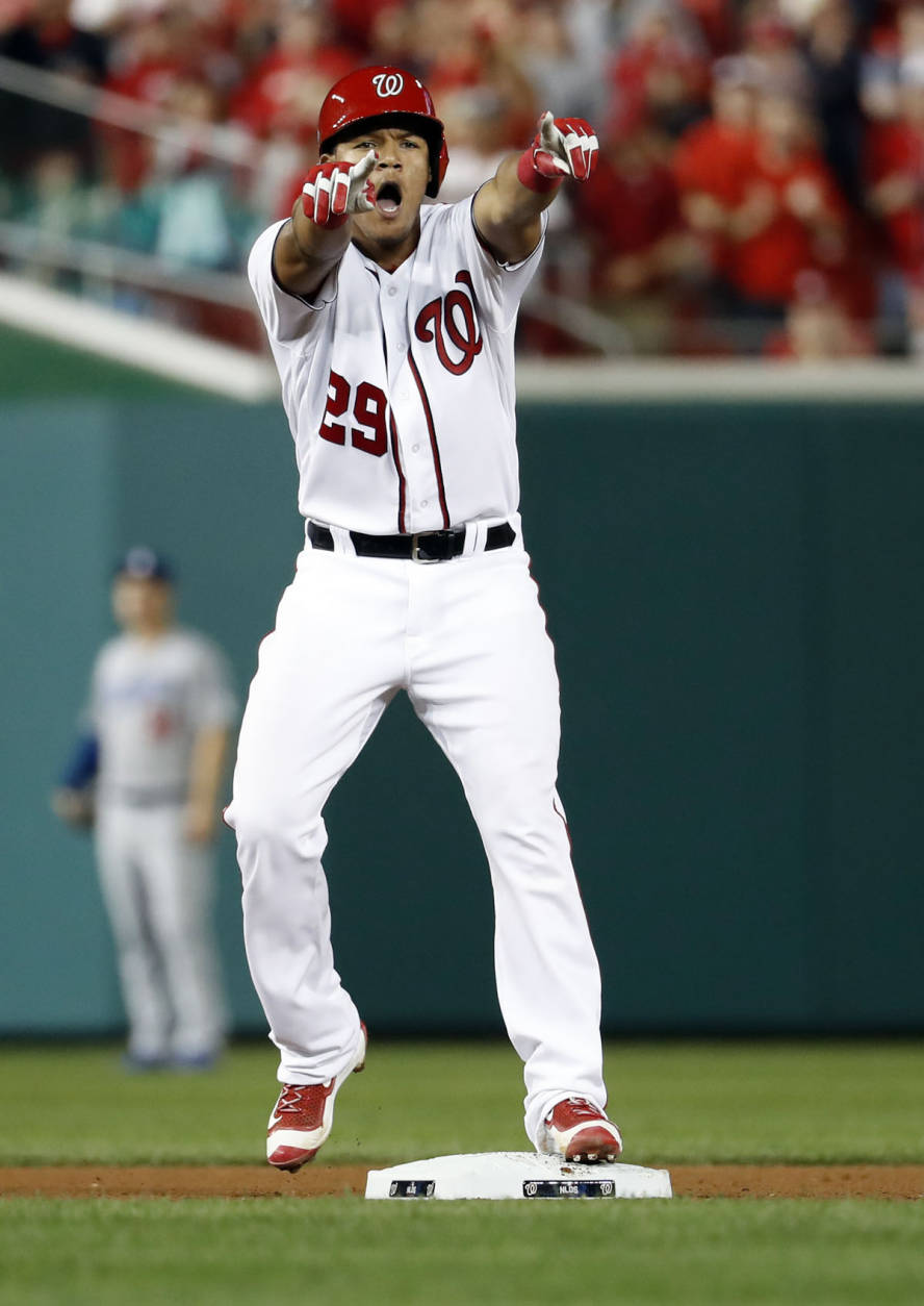 Washington Nationals' Pedro Severino celebrates his double against the Los Angeles Dodgers while standing on second base during the fourth inning of Game 1 of a baseball National League Division Series at Nationals Park, Friday, Oct. 7, 2016, in Washington. (AP Photo/Alex Brandon)