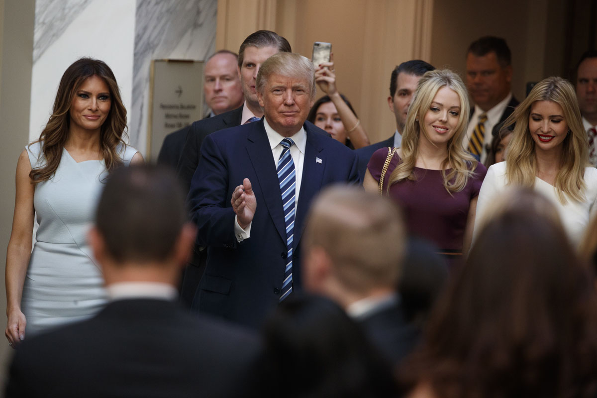 Republican presidential candidate Donald Trump, accompanied by, from left, Melania Trump, Eric Trump, Donald Trump Jr., Tiffany Trump and Ivanka Trump, arrives for a ribbon cutting ceremony during the grand opening of the Trump International Hotel- Old Post Office, Wednesday, Oct. 26, 2016, in Washington. (AP Photo/ Evan Vucci)