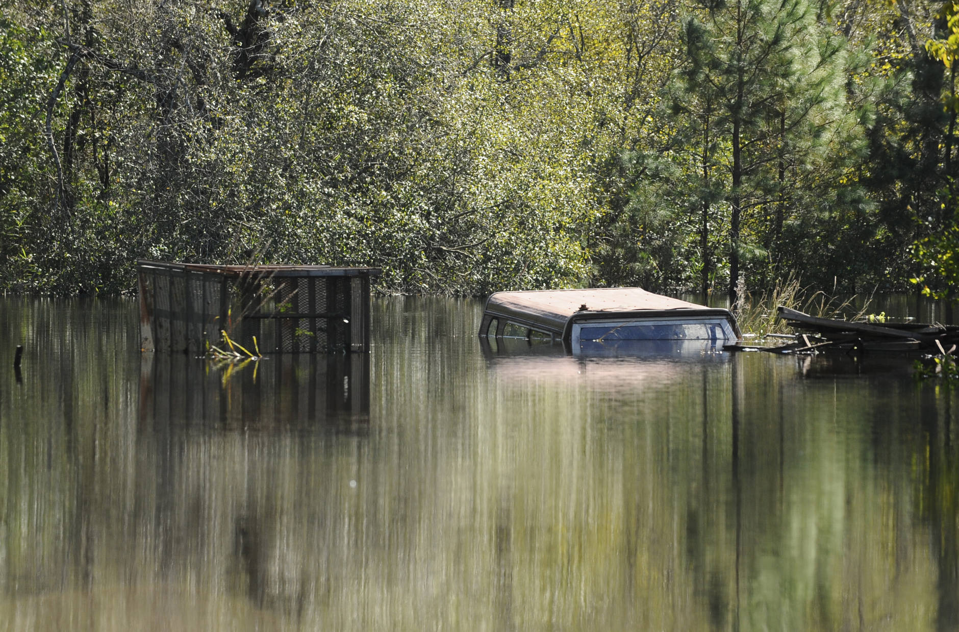 Debris and a pickup truck are submerged under floodwater on Tuesday, Oct. 11, 2016, in Nichols, S.C. About 150 people were rescued by boats from flooding in the riverside village of Nichols on Monday. (AP Photo/Rainier Ehrhardt)