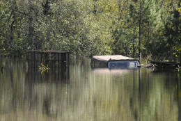 Debris and a pickup truck are submerged under floodwater on Tuesday, Oct. 11, 2016, in Nichols, S.C. About 150 people were rescued by boats from flooding in the riverside village of Nichols on Monday. (AP Photo/Rainier Ehrhardt)