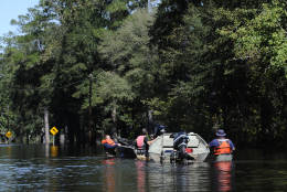 People use a boat to navigate floodwaters on Highway 9, Tuesday, Oct. 11, 2016, in Nichols, S.C. About 150 people were rescued by boats from flooding in the riverside village of Nichols on Monday. (AP Photo/Rainier Ehrhardt)