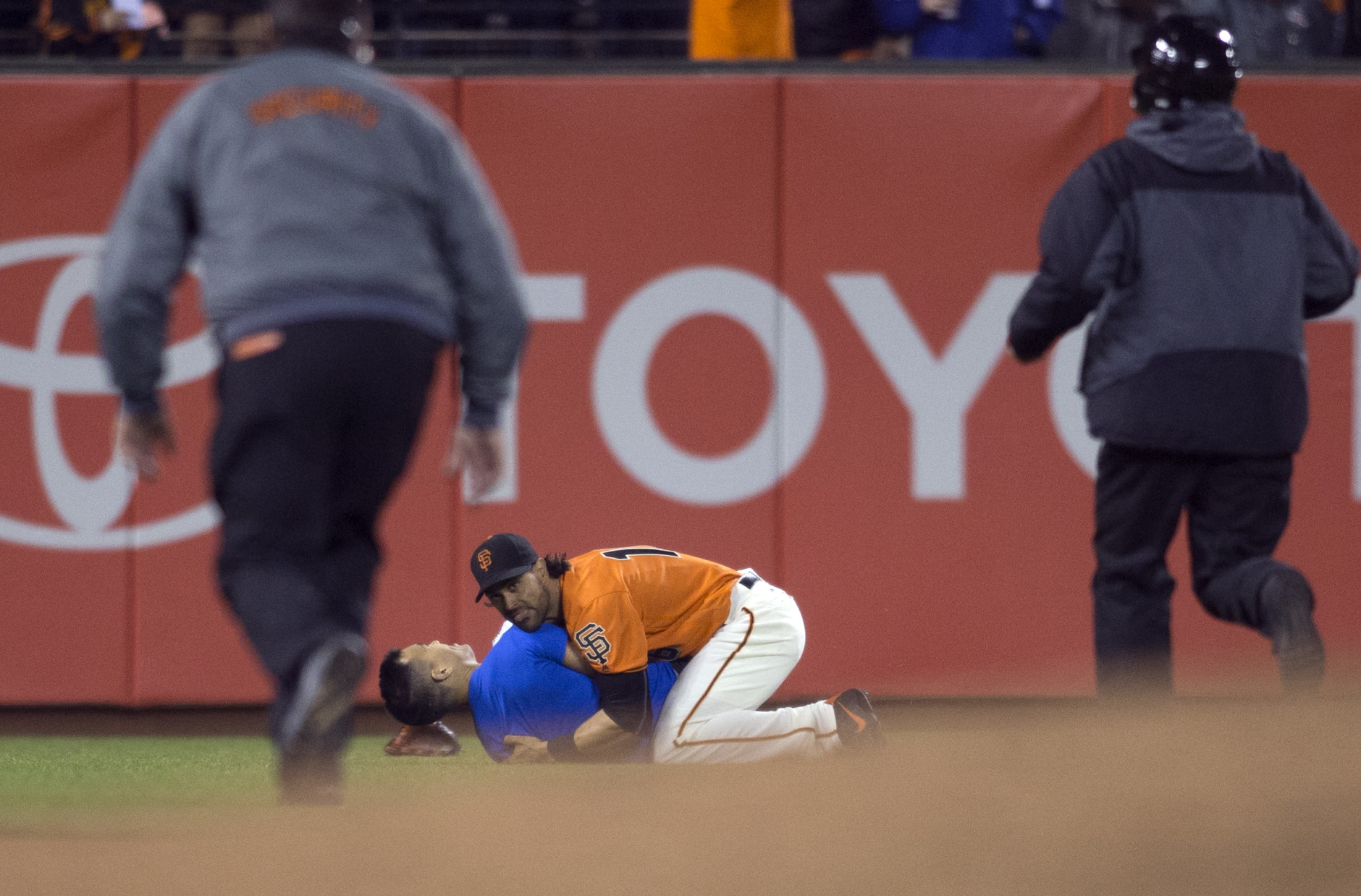 San Francisco Giants’ Angel Pagan (16) holds down a man who ran onto the field during the fourth inning of the Giants' baseball game against the Los Angeles Dodgers, Friday, Sept. 30, 2016, in San Francisco. (AP Photo/D. Ross Cameron)