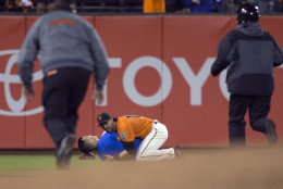 San Francisco Giants’ Angel Pagan (16) holds down a man who ran onto the field during the fourth inning of the Giants' baseball game against the Los Angeles Dodgers, Friday, Sept. 30, 2016, in San Francisco. (AP Photo/D. Ross Cameron)