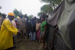 A civil protection worker, left, asks residents to evacuate the area near the Grise river, prior the arrival of Hurricane Matthew, in Tabarre, Haiti, Monday, Oct. 3, 2016. The center of Hurricane Matthew is expected to pass near or over southwestern Haiti on Tuesday, but the area is already experiencing rain from the outer bands of the storm. (AP Photo/Dieu Nalio Chery)