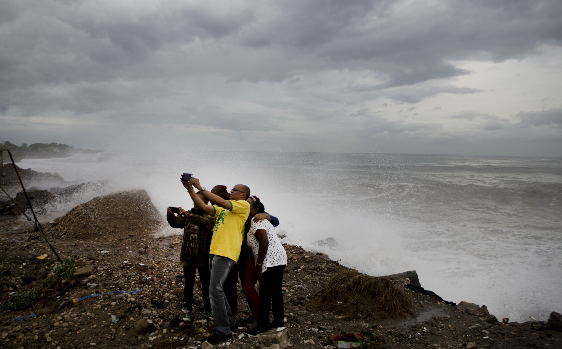 People take a photo as they stand on the coast watching the surf produced by Hurricane Matthew, on the outskirts of Kingston, Jamaica, Monday, Oct. 3, 2016. A hurricane warning is in effect for Jamaica, Haiti, and the Cuban provinces of Guantanamo, Santiago de Cuba, Holguin, Granma and Las Tunas - as well as the southeastern Bahamas. (AP Photo/Eduardo Verdugo)