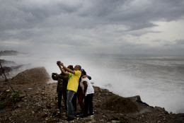 People take a photo as they stand on the coast watching the surf produced by Hurricane Matthew, on the outskirts of Kingston, Jamaica, Monday, Oct. 3, 2016. A hurricane warning is in effect for Jamaica, Haiti, and the Cuban provinces of Guantanamo, Santiago de Cuba, Holguin, Granma and Las Tunas - as well as the southeastern Bahamas. (AP Photo/Eduardo Verdugo)