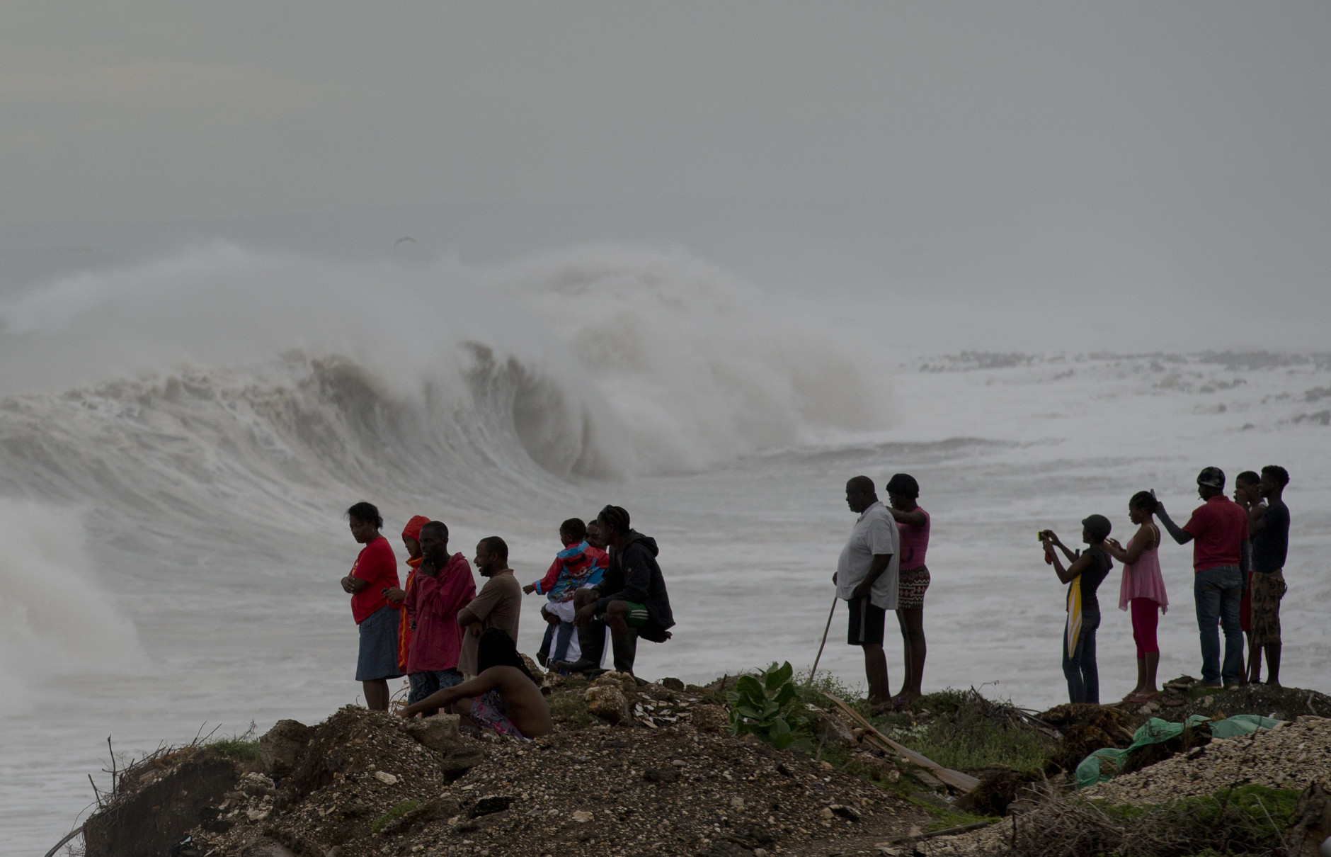 People stand on the coast watching the surf produced by Hurricane Matthew, on the outskirts of Kingston, Jamaica, Monday, Oct. 3, 2016. A hurricane warning is in effect for Jamaica, Haiti, and the Cuban provinces of Guantanamo, Santiago de Cuba, Holguin, Granma and Las Tunas - as well as the southeastern Bahamas. (AP Photo/Eduardo Verdugo)