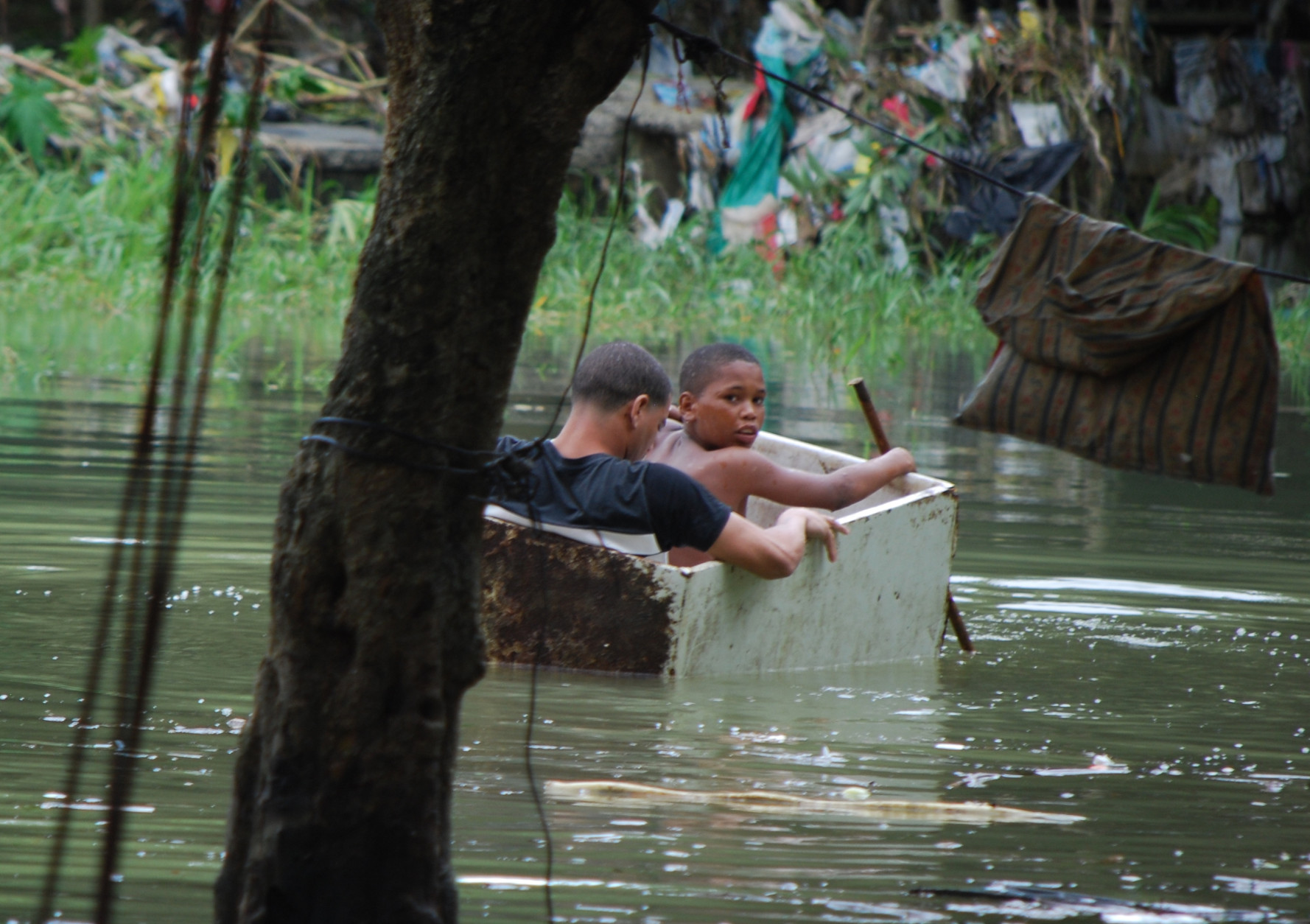 Two boys float in an old wooden box in an area flooded by heavy rains caused by Hurricane Matthew, in La Puya slum, in the Arroyo Hondo creek in Santo Domingo, Dominican Republic, Tuesday, Oct. 4, 2016. Matthew roared into the southwestern coast of the island of Hispaniola with devastating storm conditions as it headed north toward Cuba and the eastern coast of Florida. (AP Photo/Ezequiel Abiu Lopez)