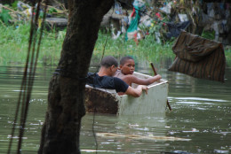 Two boys float in an old wooden box in an area flooded by heavy rains caused by Hurricane Matthew, in La Puya slum, in the Arroyo Hondo creek in Santo Domingo, Dominican Republic, Tuesday, Oct. 4, 2016. Matthew roared into the southwestern coast of the island of Hispaniola with devastating storm conditions as it headed north toward Cuba and the eastern coast of Florida. (AP Photo/Ezequiel Abiu Lopez)