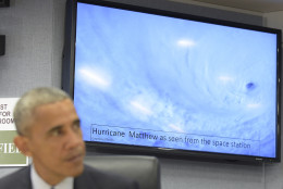 With a video of Hurricane Matthew in the background, President Barack Obama speaks during a briefing to update him on the hurricane during a visit to FEMA headquarters in Washington, Wednesday, Oct. 5, 2016. (AP Photo/Susan Walsh)