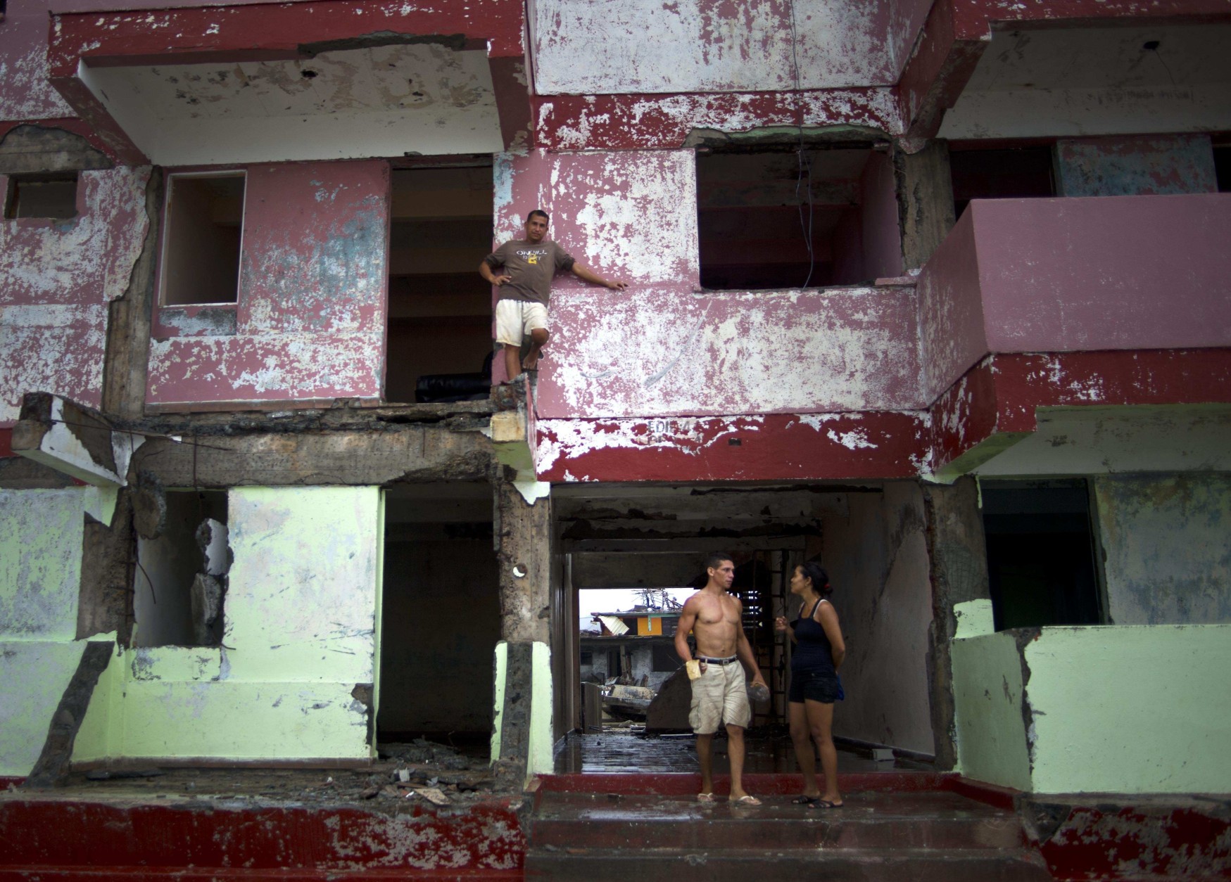A man looks from the balcony of his house damaged by Hurricane Matthew in Baracoa, Cuba, Wednesday, Oct. 5, 2016. The hurricane rolled across the sparsely populated tip of Cuba overnight, destroying dozens of homes in Cuba's easternmost city, Baracoa, leaving hundreds of others damaged.  (AP Photo/Ramon Espinosa)