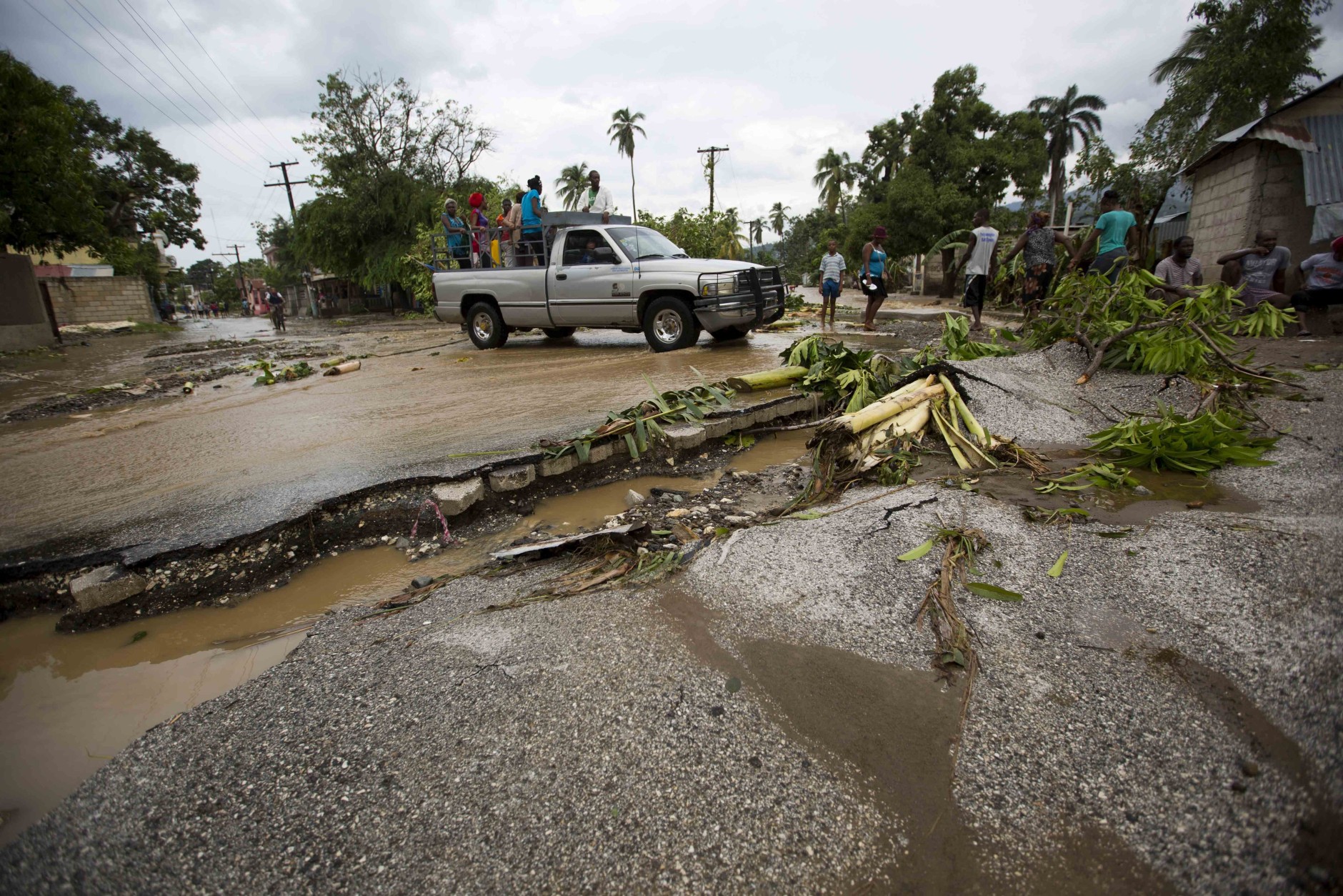 A truck negotiates a road damaged by Hurricane Matthew, in Petit Goave, Haiti, Wednesday, Oct. 5, 2016. Rescue workers in Haiti struggled to reach cutoff towns and learn the full extent of the death and destruction caused by Hurricane Matthew as the storm began battering the Bahamas on Wednesday and triggered large-scale evacuations along the U.S. East Coast. ( AP Photo/Dieu Nalio Chery)