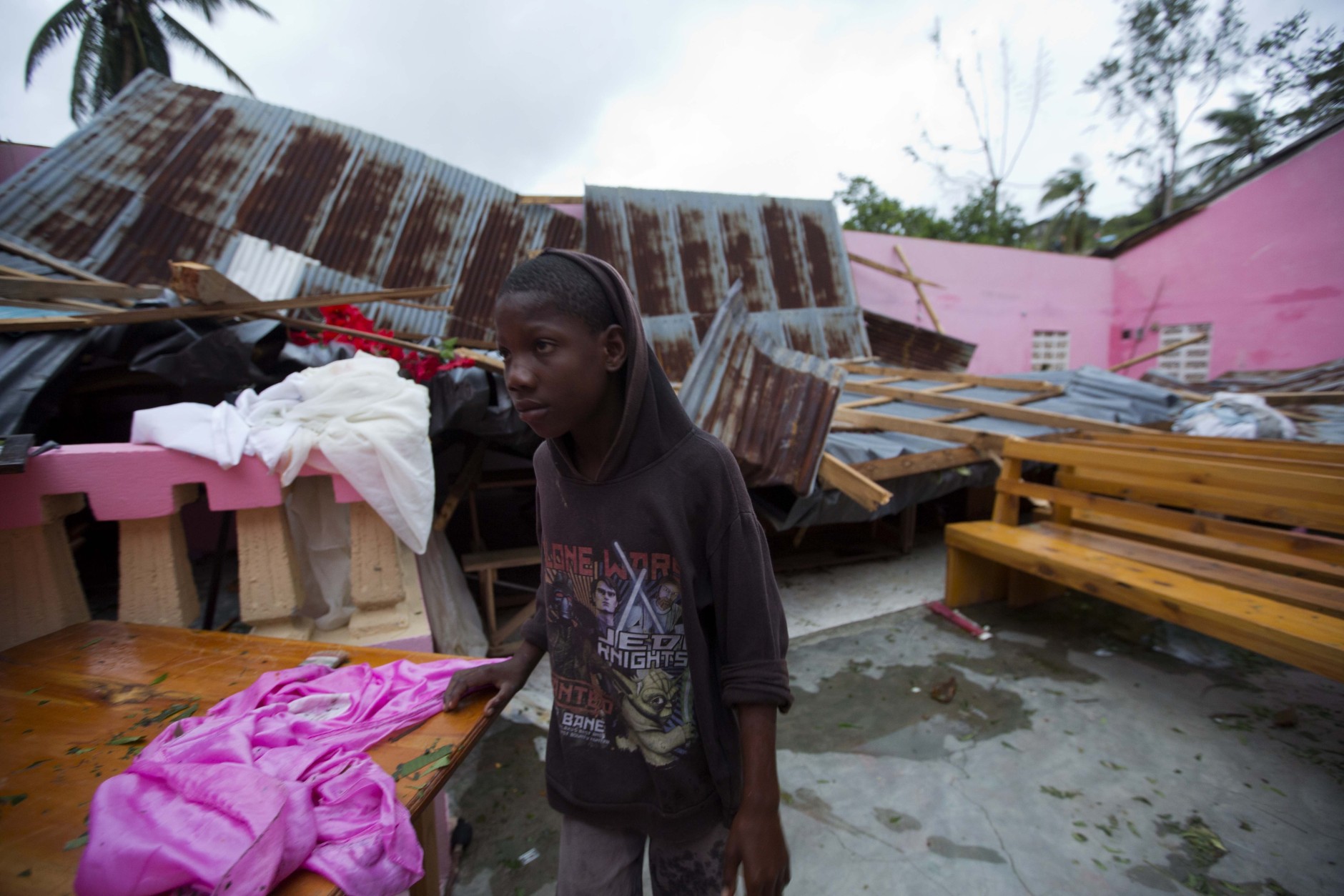 A boy stands inside a church after it was damaged by Hurricane Matthew in Saint-Louis, Haiti, Wednesday, Oct. 5, 2016.  Rescue workers in Haiti struggled to reach cutoff towns and learn the full extent of the death and destruction caused by Hurricane Matthew as the storm began battering the Bahamas on Wednesday and triggered large-scale evacuations along the U.S. East Coast. ( AP Photo/Dieu Nalio Chery)