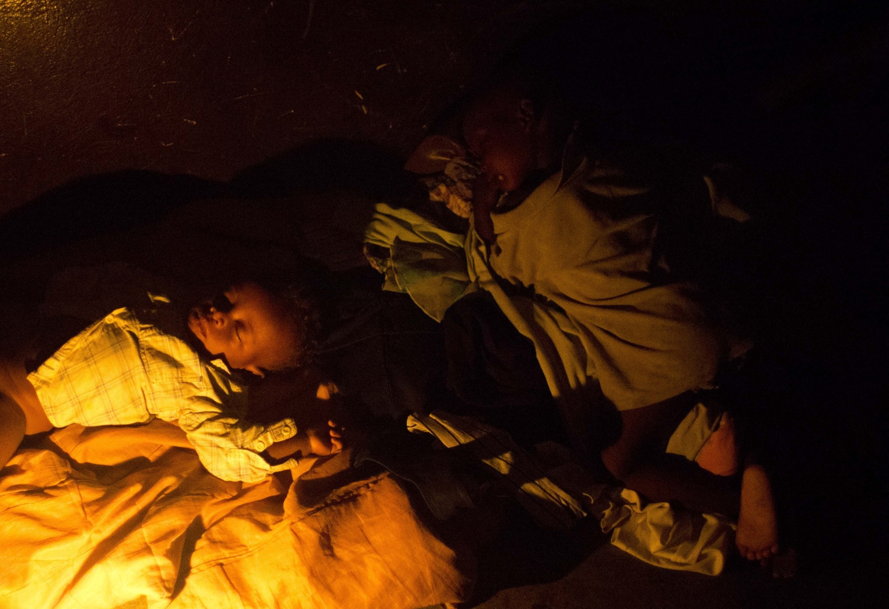 Children sleep in a shelter in Les Cayes, Haiti, Wednesday, Oct. 5, 2016. Hurricane Matthew slammed into Haiti's southwestern tip with howling, 145 mph winds destroying the bridge and cutting off road communication with the worst hit areas. ( AP Photo/Dieu Nalio Chery)