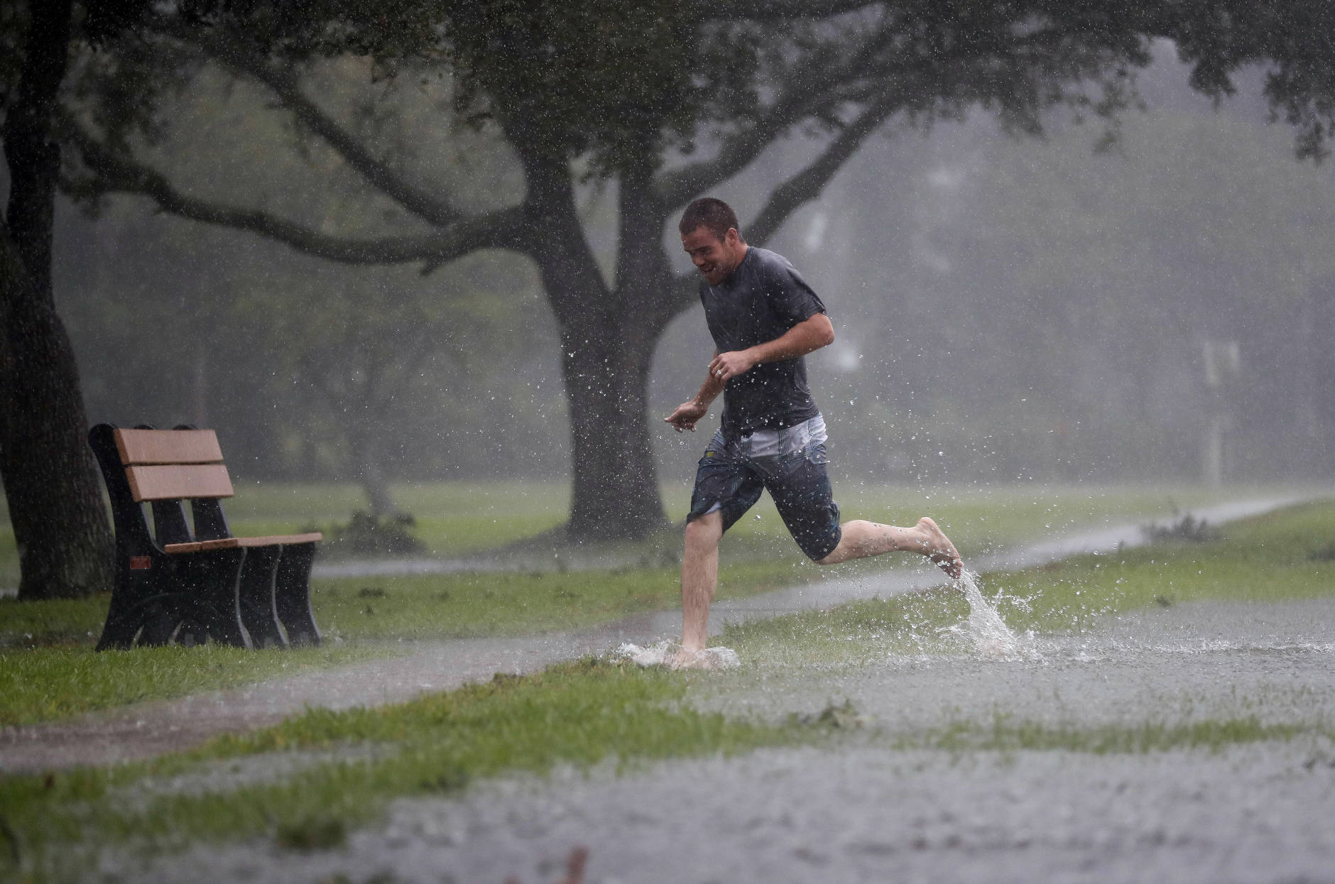 Austin Massett runs through a area beginning to flood as Hurricane Matthew moves closer to St. Augustine, Fla., Friday, Oct. 7, 2016.  Matthew was downgraded to a Category 3 hurricane overnight, and its storm center hung just offshore as it moved up the Florida coastline, sparing communities its full 120 mph winds. (AP Photo/John Bazemore)