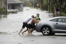 Noah Simons steers as his car is pushed out of flood waters caused by Hurricane Matthew, Friday, Oct. 7, 2016, in Daytona Beach, Fla. Hurricane Matthew spared Florida’s most heavily populated stretch from a catastrophic blow Friday but threatened some of the South’s most historic and picturesque cities with ruinous flooding and wind damage as it pushed its way up the coastline.  (AP Photo/Eric Gay)